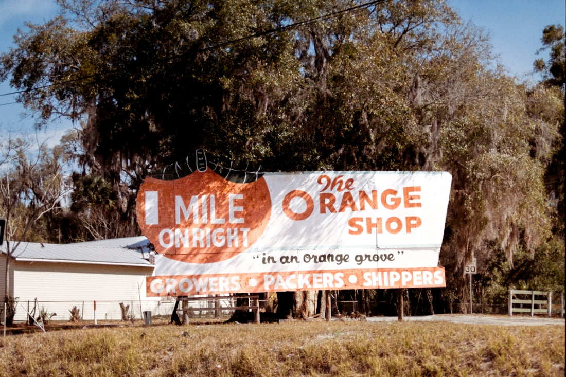 The orange shop billboard with 1 mile sign.